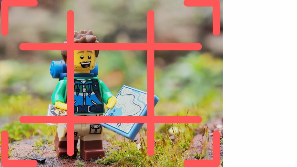Lego figure holding a map with a grid overlay showing the rule of thirds