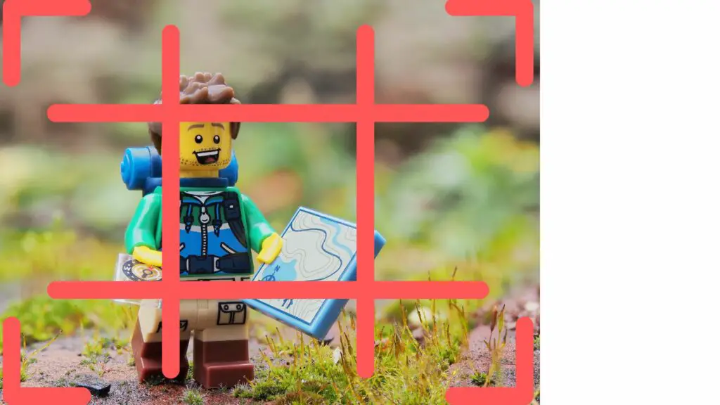 Lego figure na may hawak na mapa na may grid overlay na nagpapakita ng rule of thirds